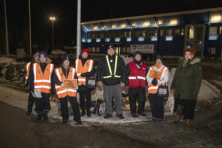 Ammattiliitto JHL:n jäseniä lakkoliiveissä Oulun keskuspesulan edustalla pimeänä aamuna.