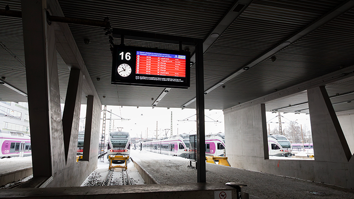 Tåg står stilla på Helsingfors tågstation. En solstrimma lyser upp skuggorna.