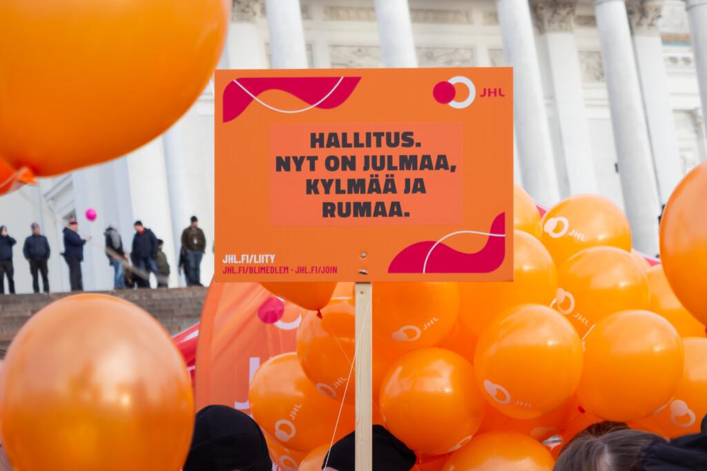 Ammattiliitto JHL:n lakkokyltti mielenosoituksessa Helsingin tuomiokirkon edustalla JHL:n ilmapallojen ympäröimänä.