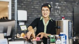 Kokki Kirsi Mäkynen asettelee ruoka-annnosta ruokalassa.